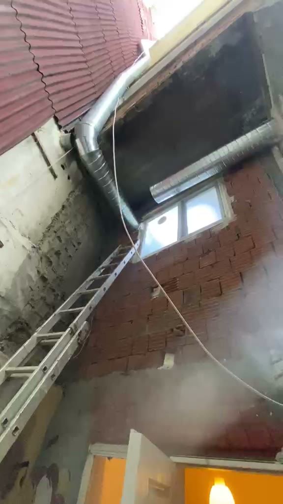Dikey boşluktaki metal boru hattı ve merdiven